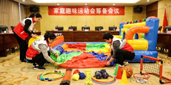 家庭趣味运动会筹备会议 - 工作人员正在布置充气城堡和运动器材