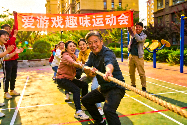 社区居民在小区空地上参与爱游戏平台组织的趣味运动会 - 拔河比赛现场气氛热烈