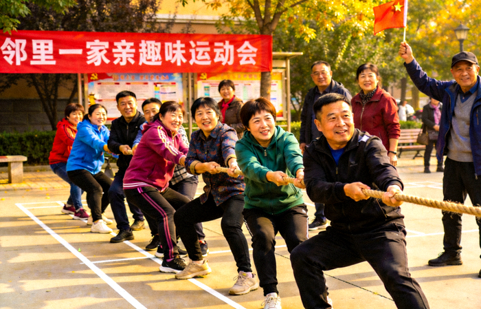 社区趣味运动会现场 - 邻里组队参与拔河比赛