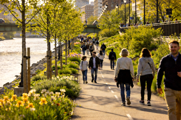 城市河畔徒步路线 - 步道上行走的人群与沿岸绿植景观
